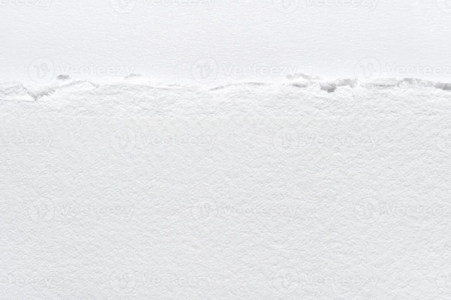 Close-up of textured torn white paper edge with detailed fibers and rough surface. photo