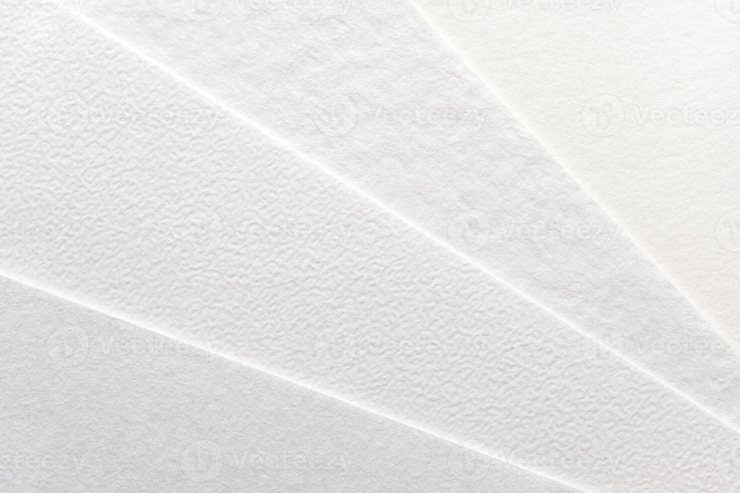 Close-up of textured white paper sheets arranged in a fan pattern. photo