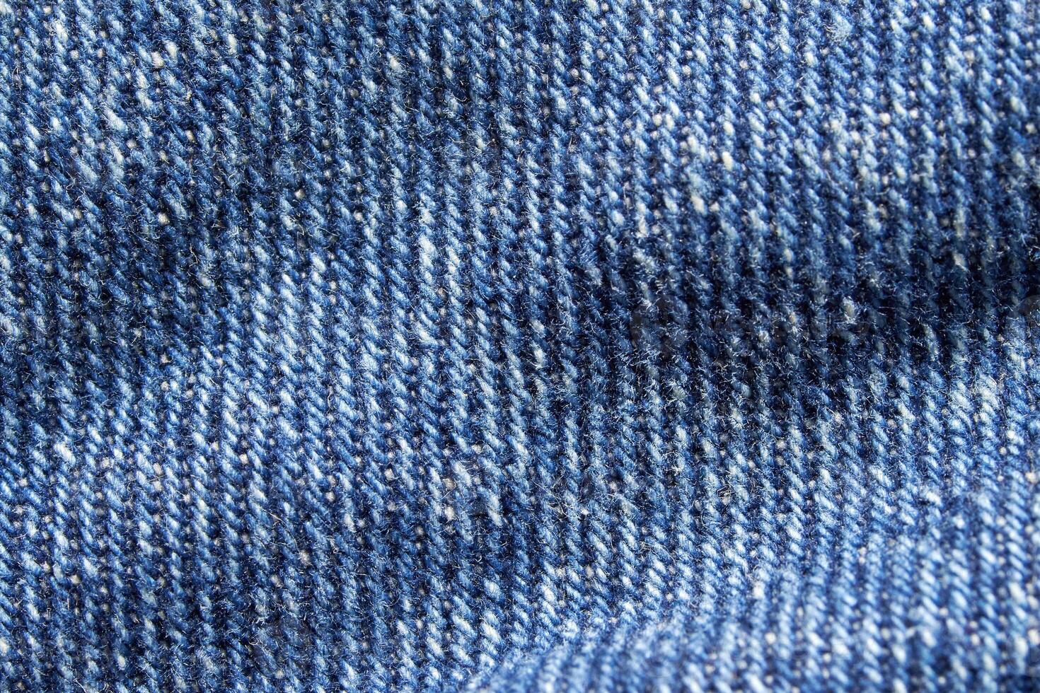 Close-up of blue denim fabric texture with detailed weave pattern and stitching. photo