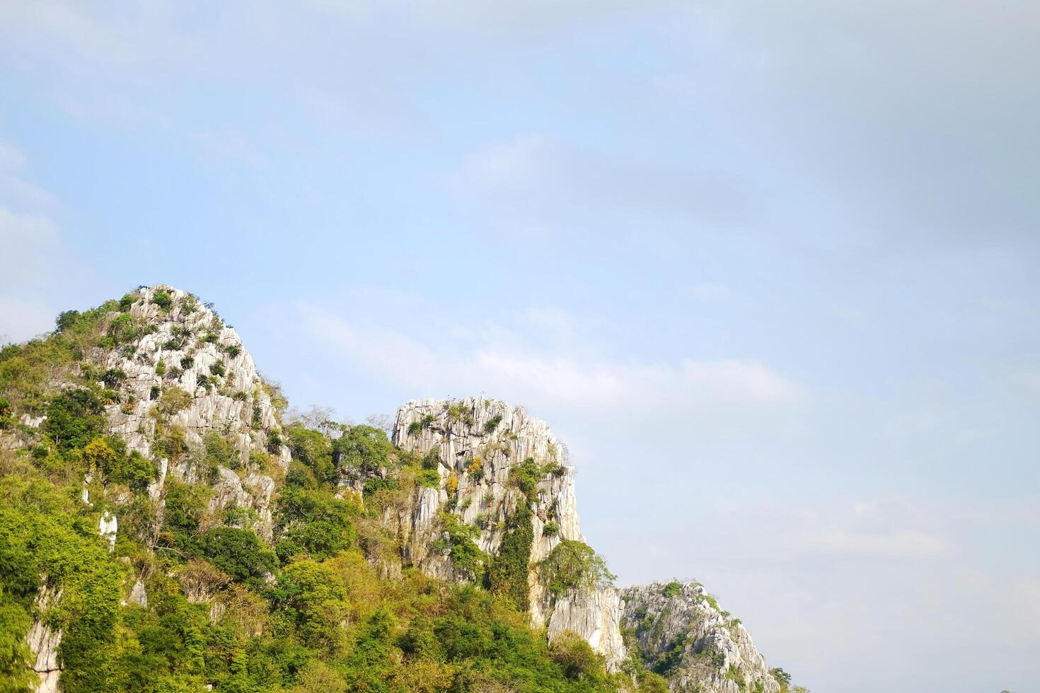 landscape rocky mountain and forest on hill with blue sky in Thailand. Copy space photo
