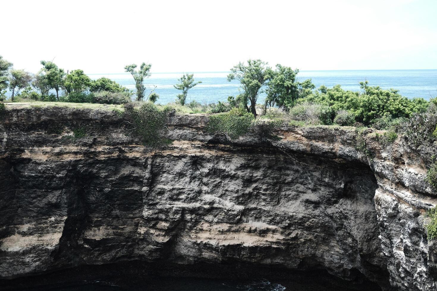 Beautiful landscape view of cave in rocky cliff of mountain and destination travel at Broken Beach Nusa Penida, Bali, Indonesia photo