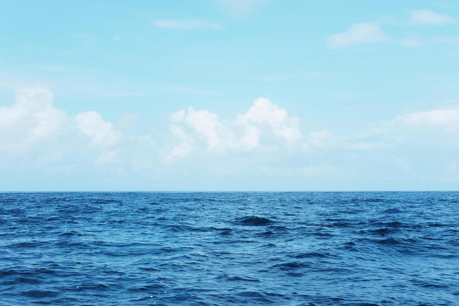 Landscape of horizontal calm blue sea with wave and cloud and blue sky in bright day. Travel destination summer of ocean in Asian. Copy space photo