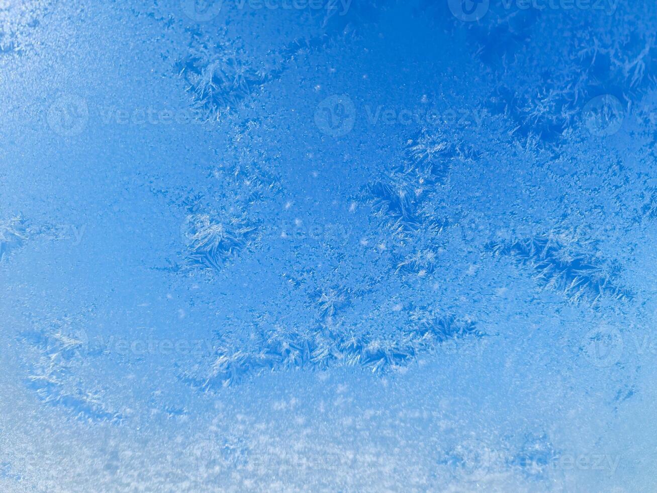 Ice crystals creating beautiful frozen patterns on window in winter photo