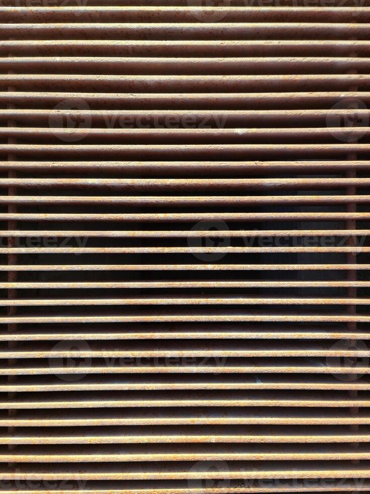Rusty metal grille creating repeating horizontal lines photo