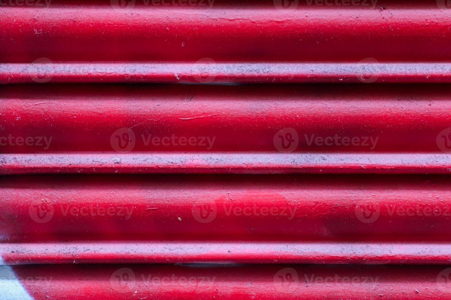Red painted metal surface forming a textured background photo