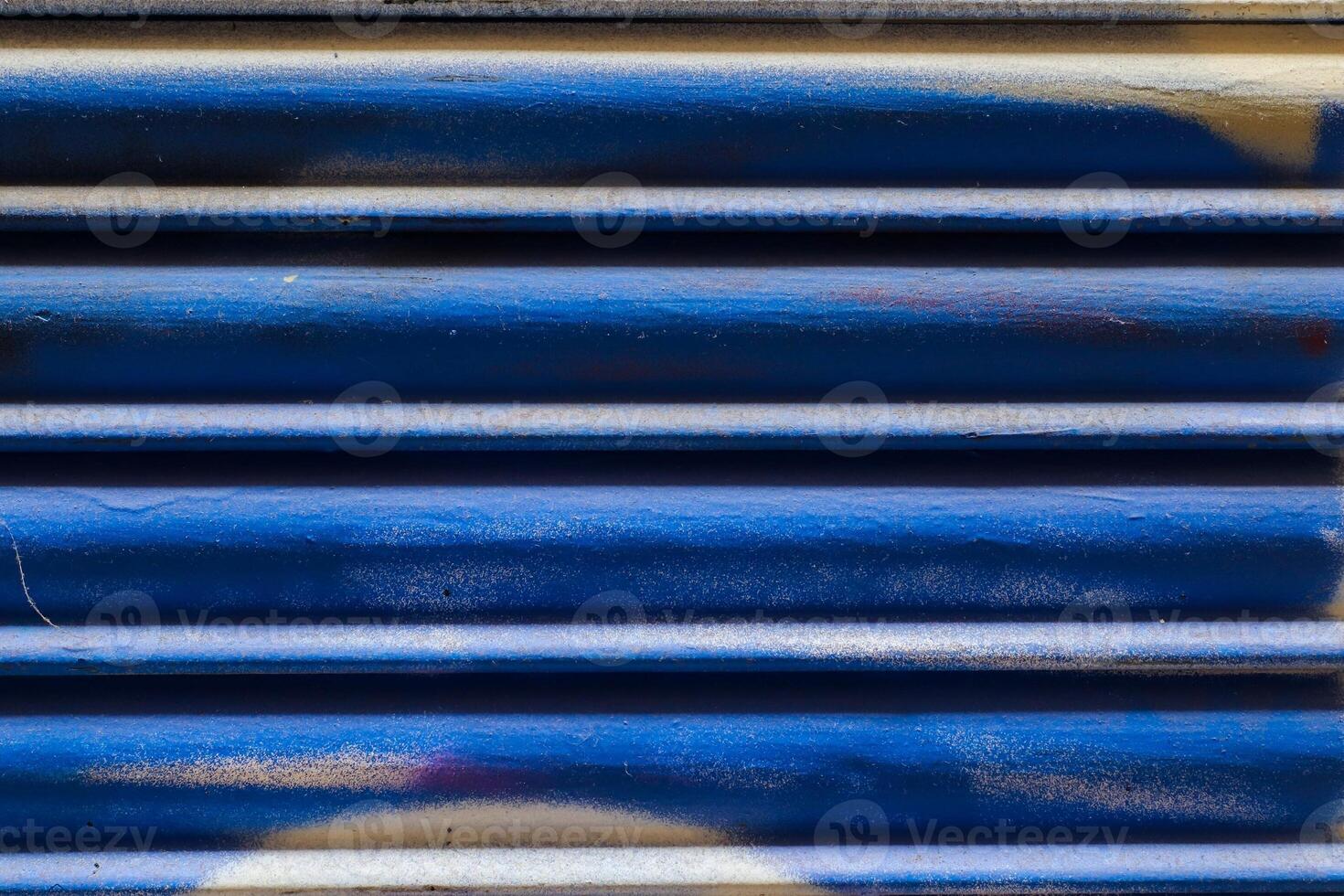 Blue metal shutter showing signs of wear and graffiti marks photo