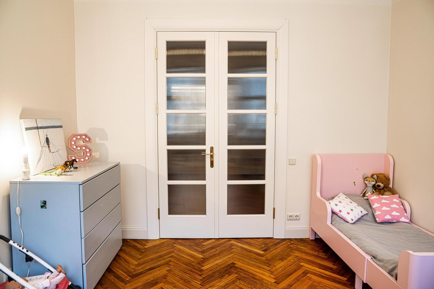Riga, Latvia, 2024 - Childrens Room with Pink Bed and Herringbone Wooden Floor photo