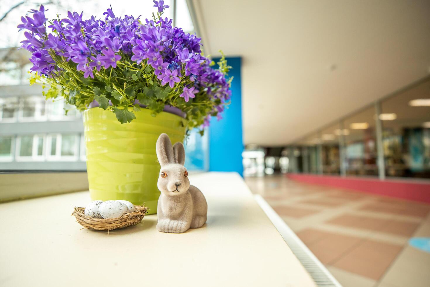 Riga, Latvia, 2024 - Indoor Display with Purple Flowers, Ceramic Rabbit, and Nest photo