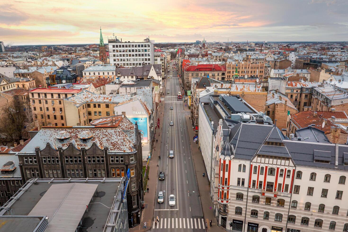 Riga, Latvia, 2024 - Aerial View of Riga Cityscape with Historic Church Spire at Sunset photo
