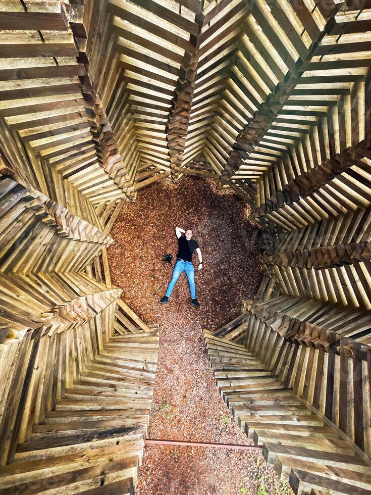 Aerial View of Person in Geometric Wooden Structure with Pebble Ground photo