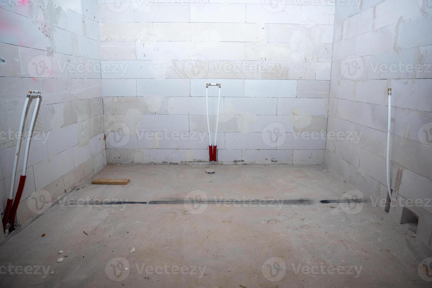 Unfinished Interior Space with Concrete Floor and Plumbing Pipes photo