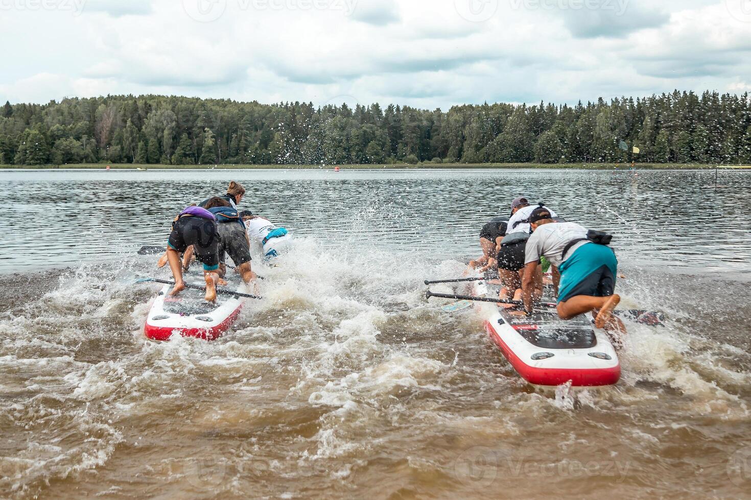 Group Paddleboarding on a Lake with Forested Background photo
