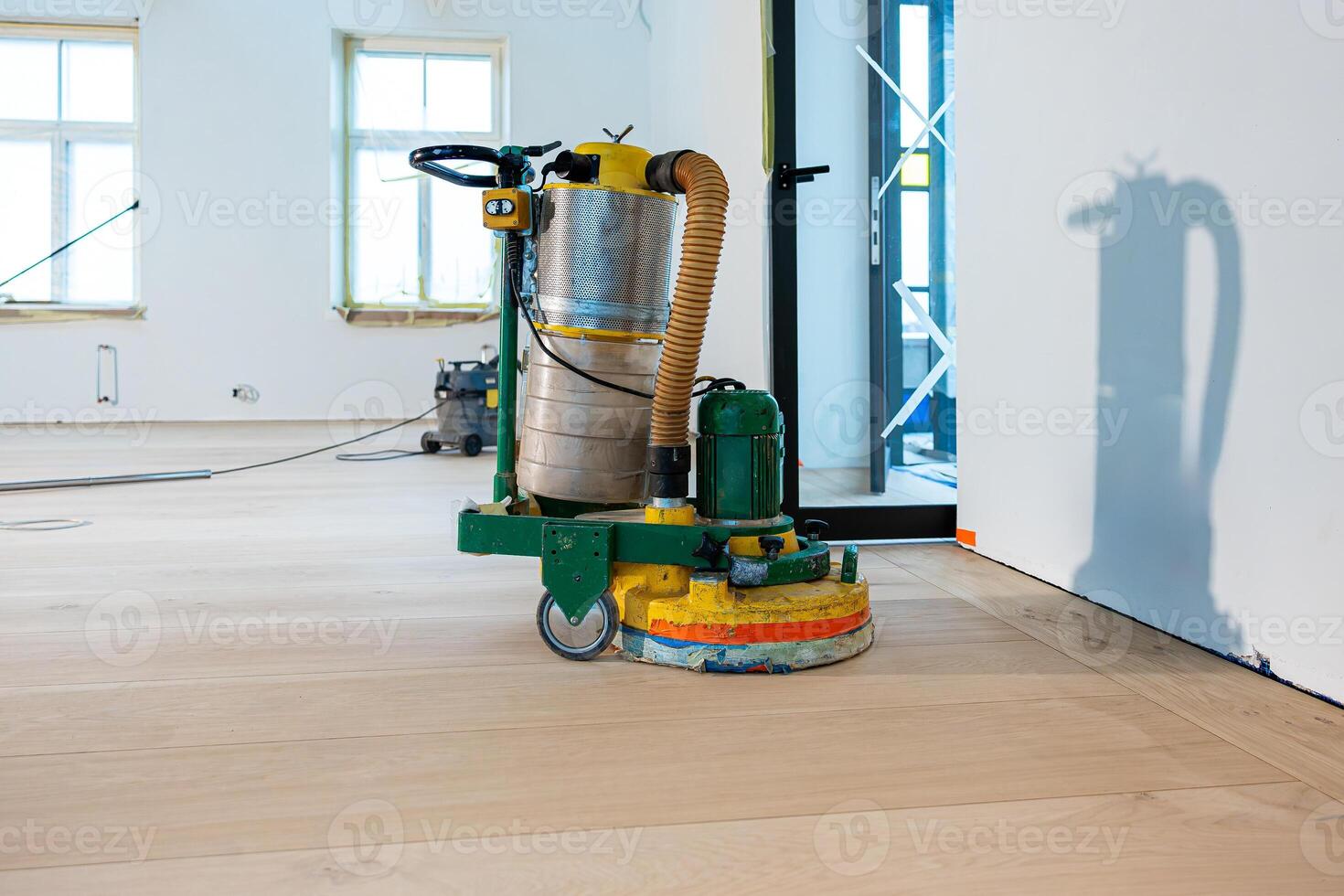 Floor Sanding Machine in Renovation Room with White Walls and Windows photo
