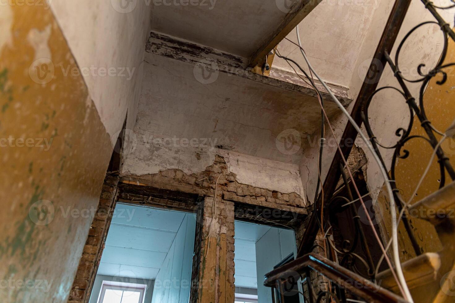 Interior of an Abandoned Building with Exposed Brickwork and Staircase photo