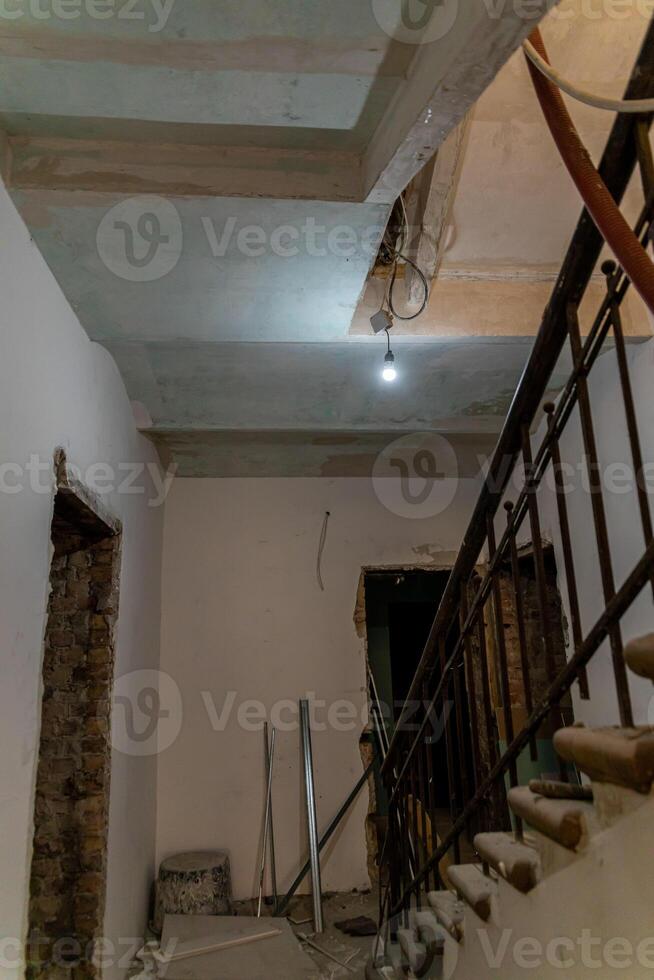 Indoor Construction Site with Exposed Brickwork and Staircase photo