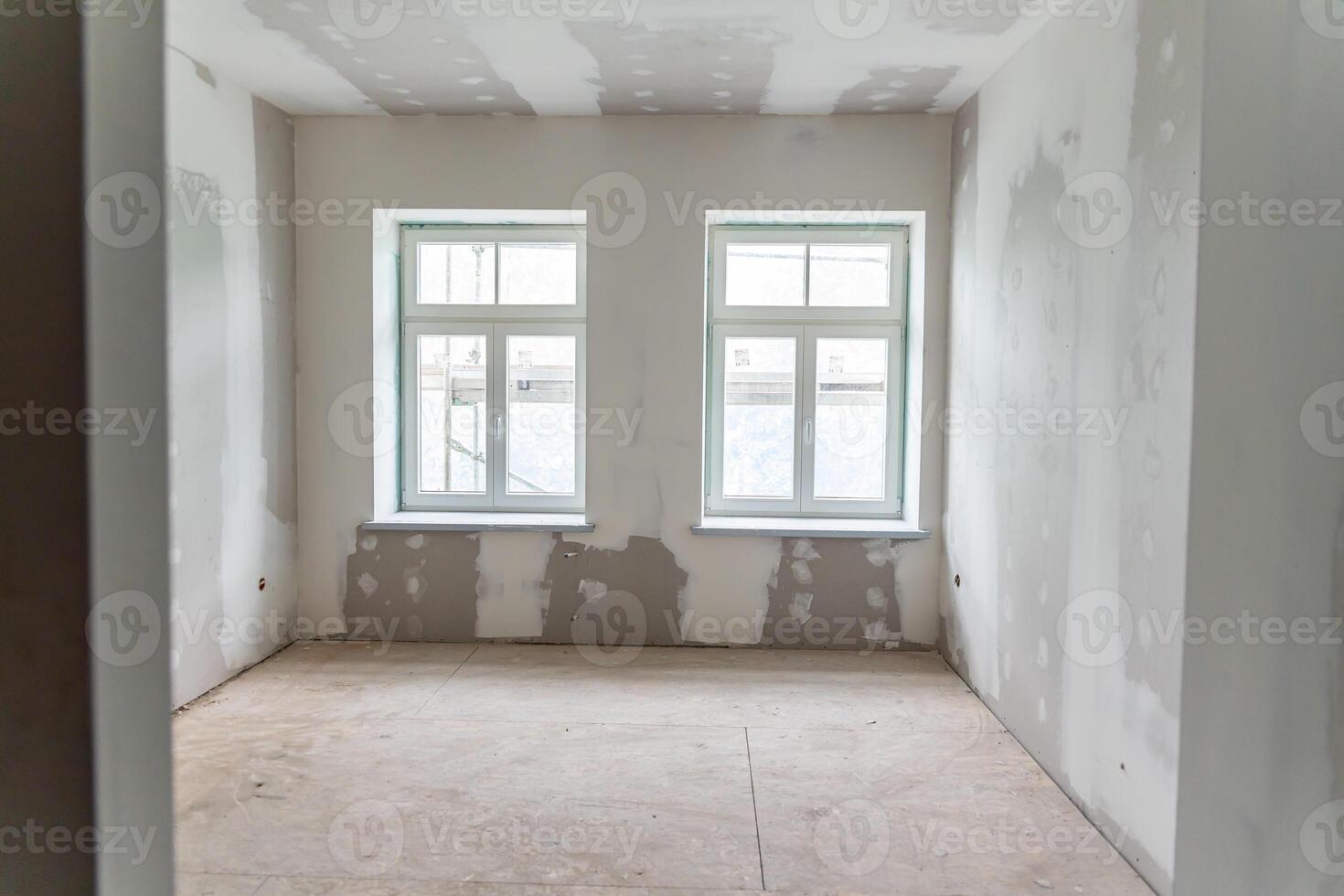 Unfinished Interior Room with Drywall and Two Rectangular Windows photo