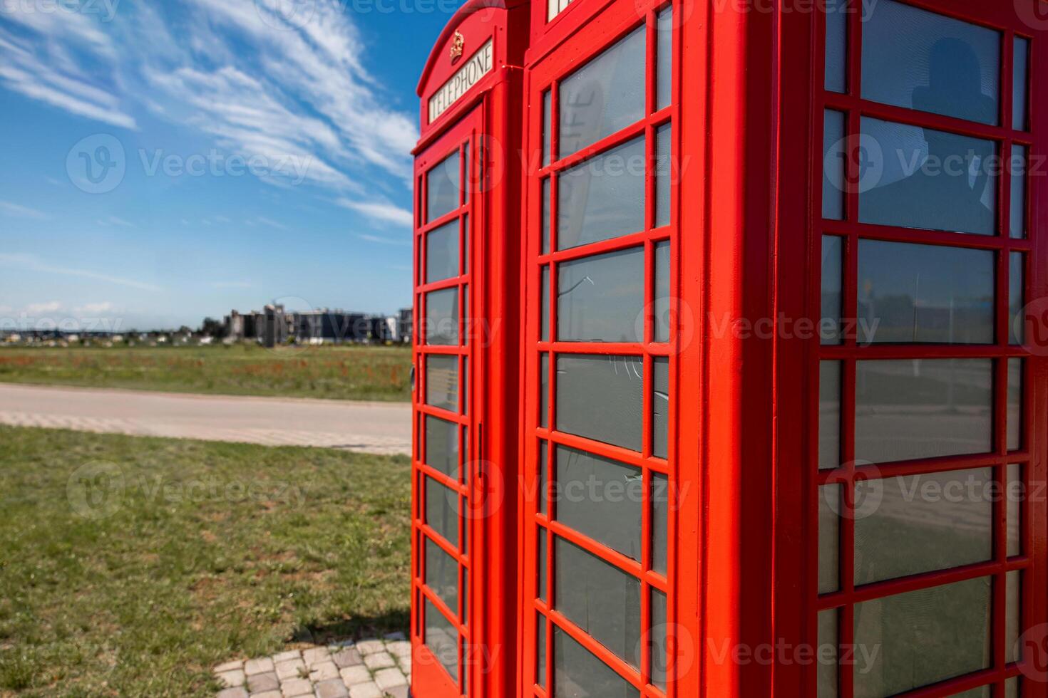 Red British Telephone Booths with Modern Buildings in the Distance photo