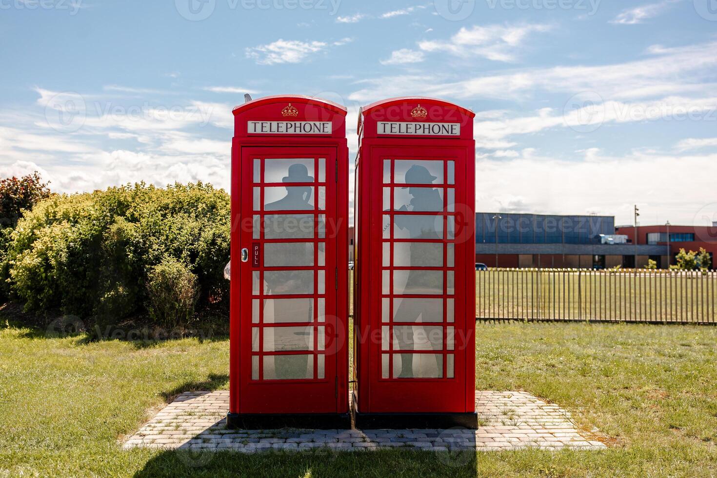 Two Red British Telephone Booths in Urban Adjacent Setting photo