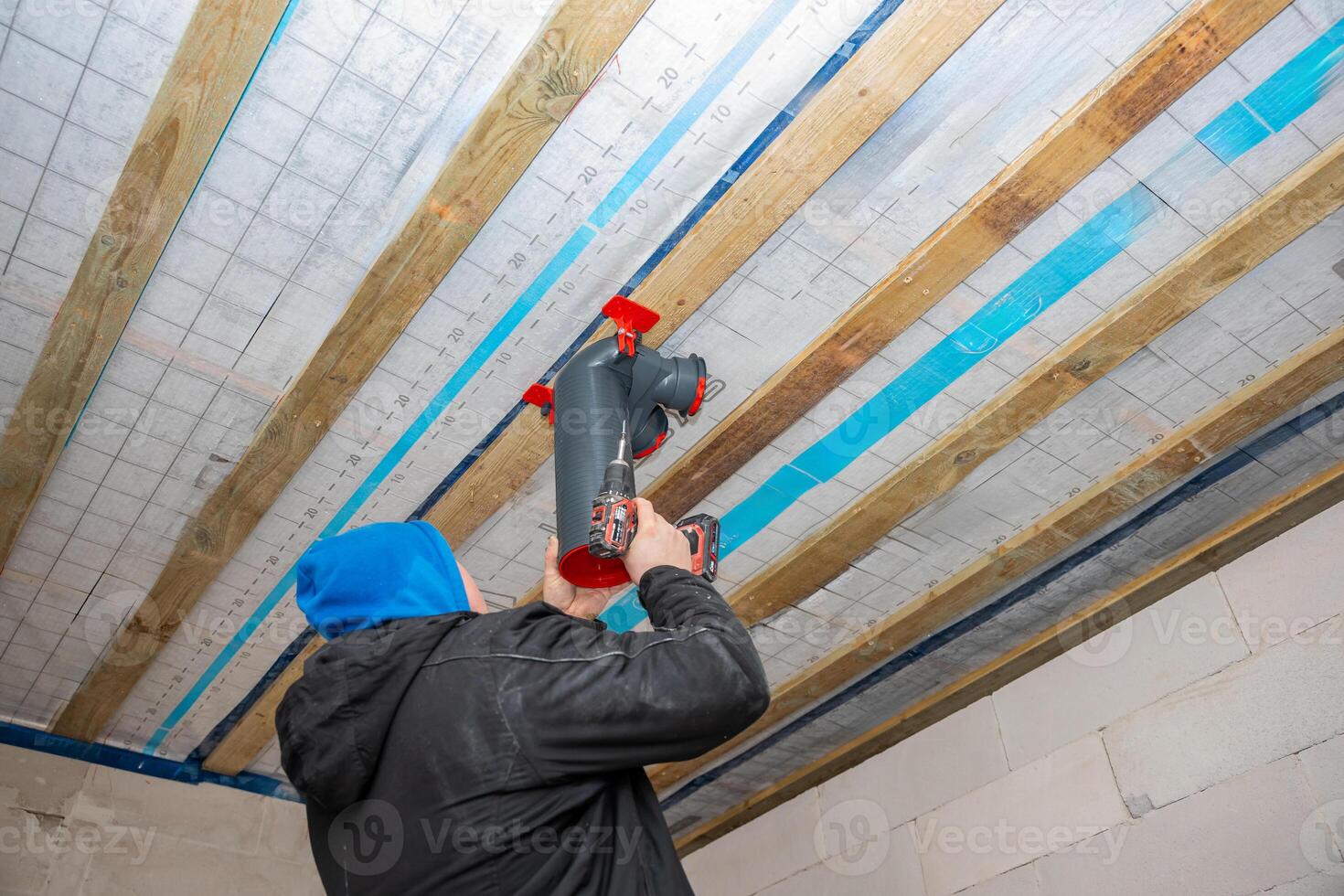 Worker Installing Heat Recovery Ventilation System on Ceiling photo