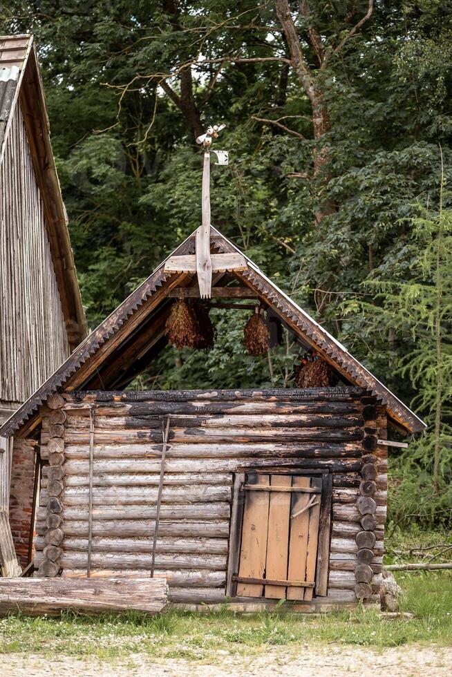 Rustic Wooden Log Structure with Decorative Roof Edging in Forest photo