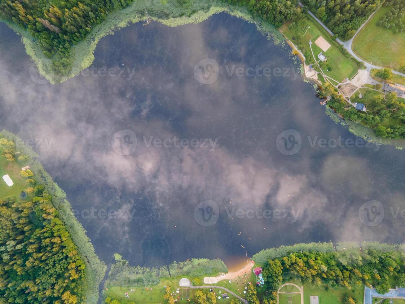Aerial View of Mist Covered Lake with Forest and Sandy Beach photo