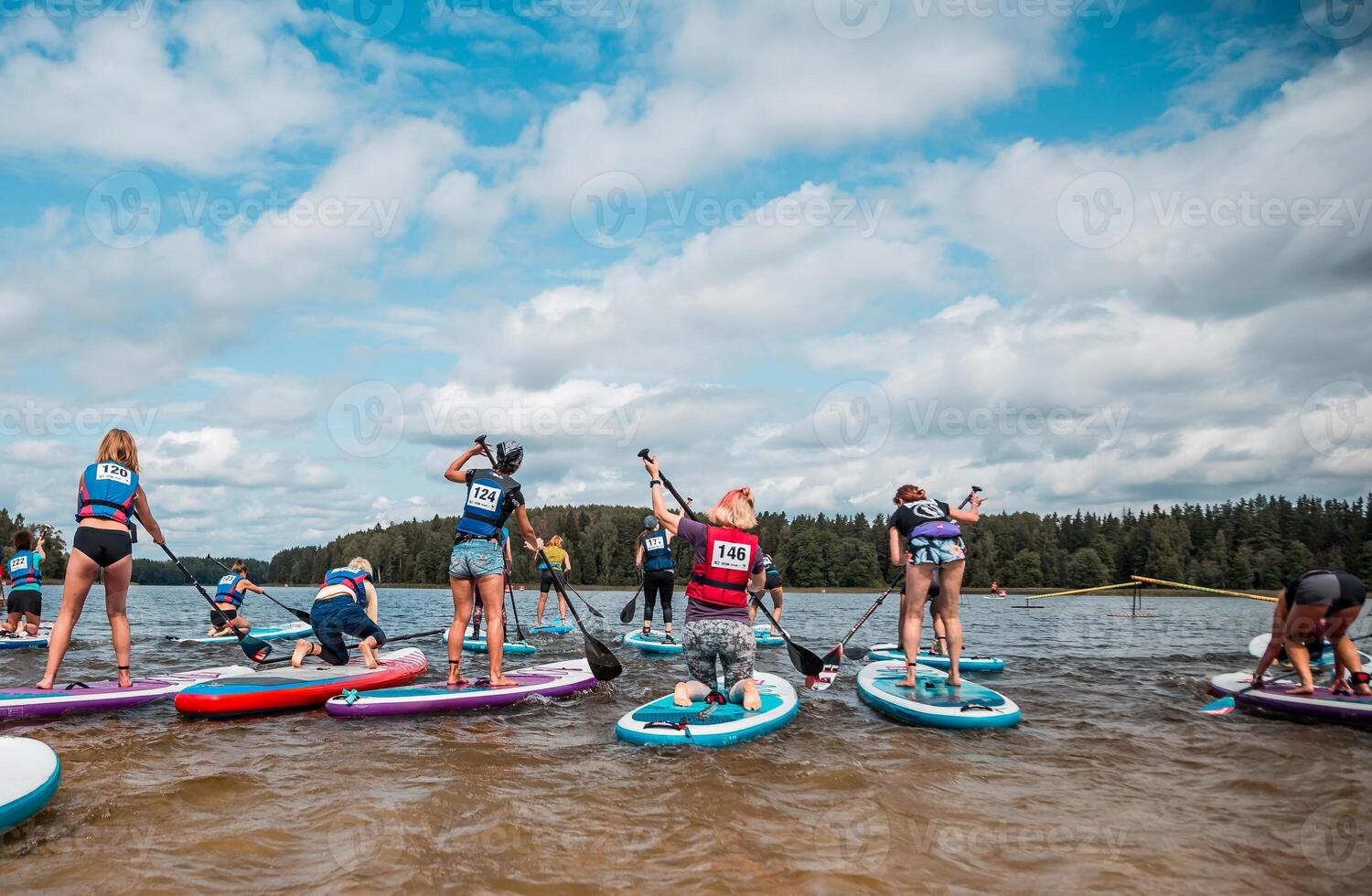 Paddleboarding Event on Calm Water with Forested Shoreline photo