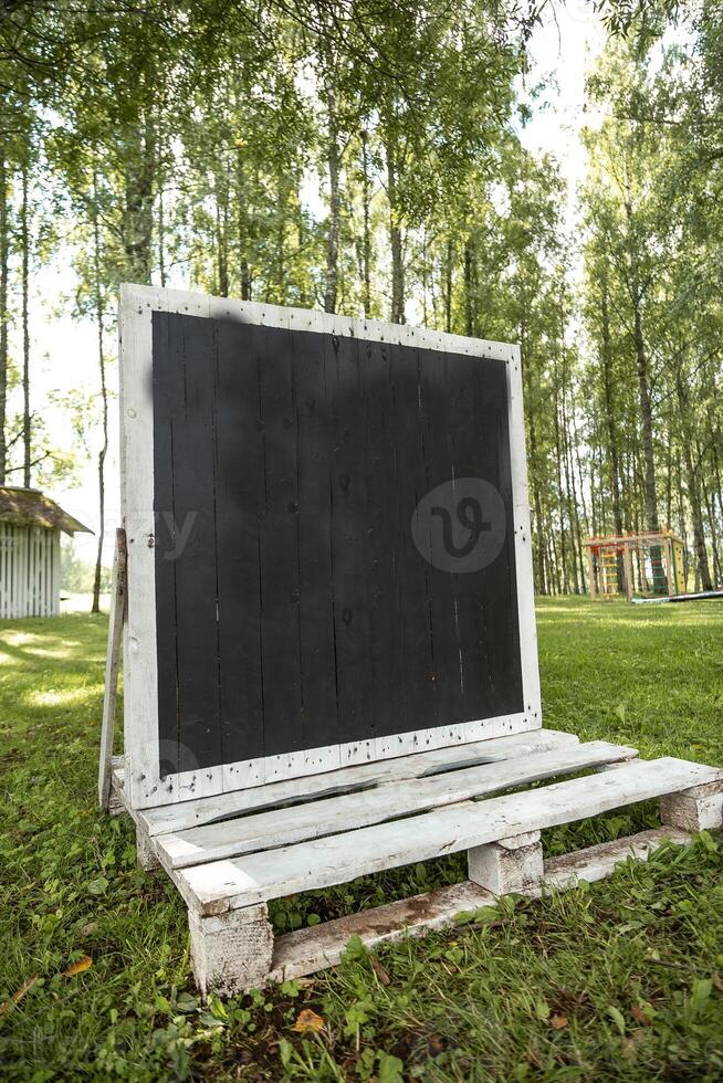 Outdoor Blackboard with Wooden Frame in a Grassy Park Setting photo