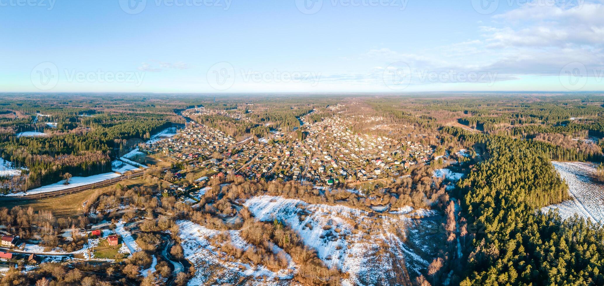 Aerial View of a Small Town with Fields, Forests, and a Winding River photo
