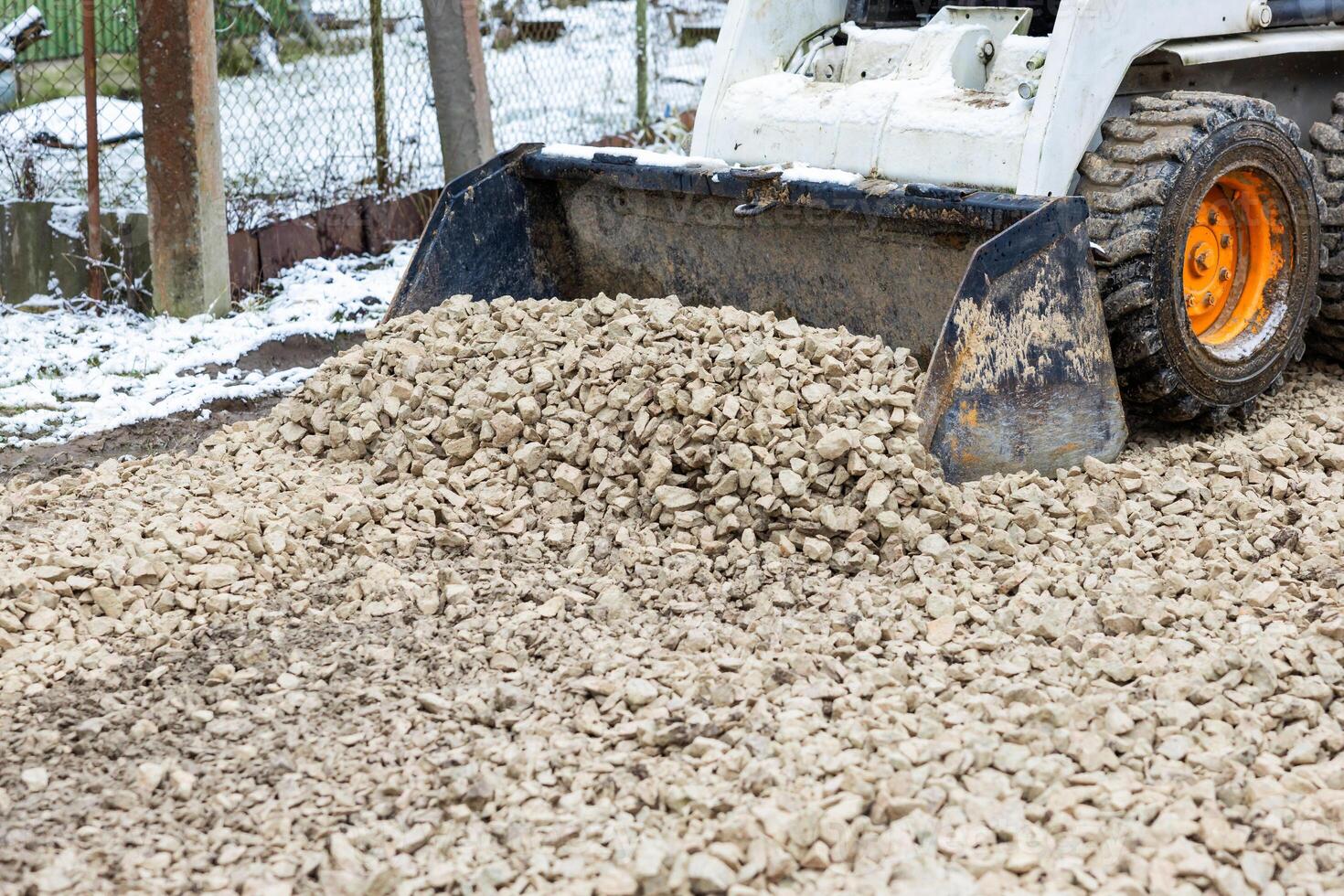 Construction Vehicle Depositing Gravel in a Snowy Environment photo