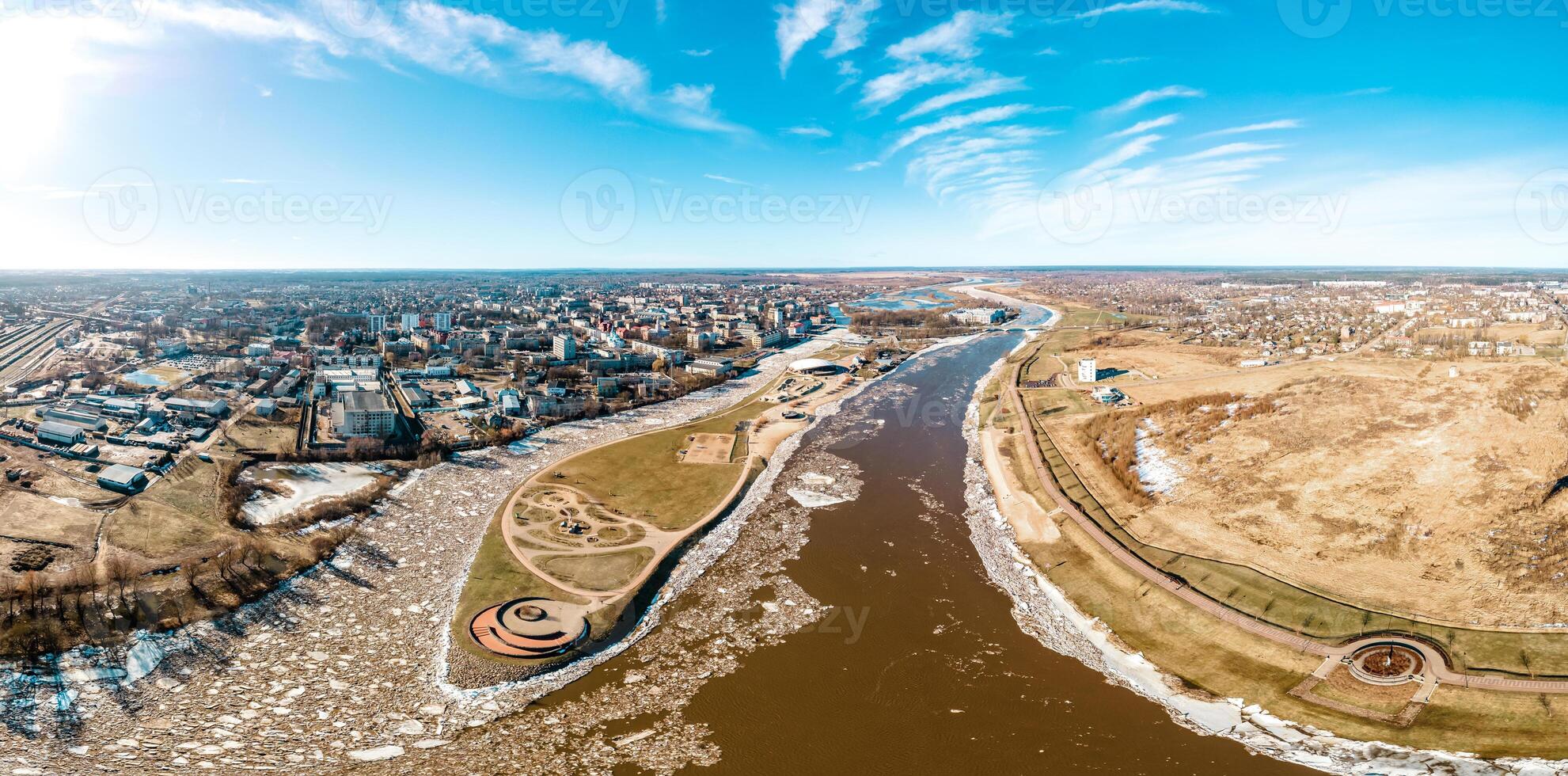 Aerial View of Cityscape with Frozen River and Circular Structure photo
