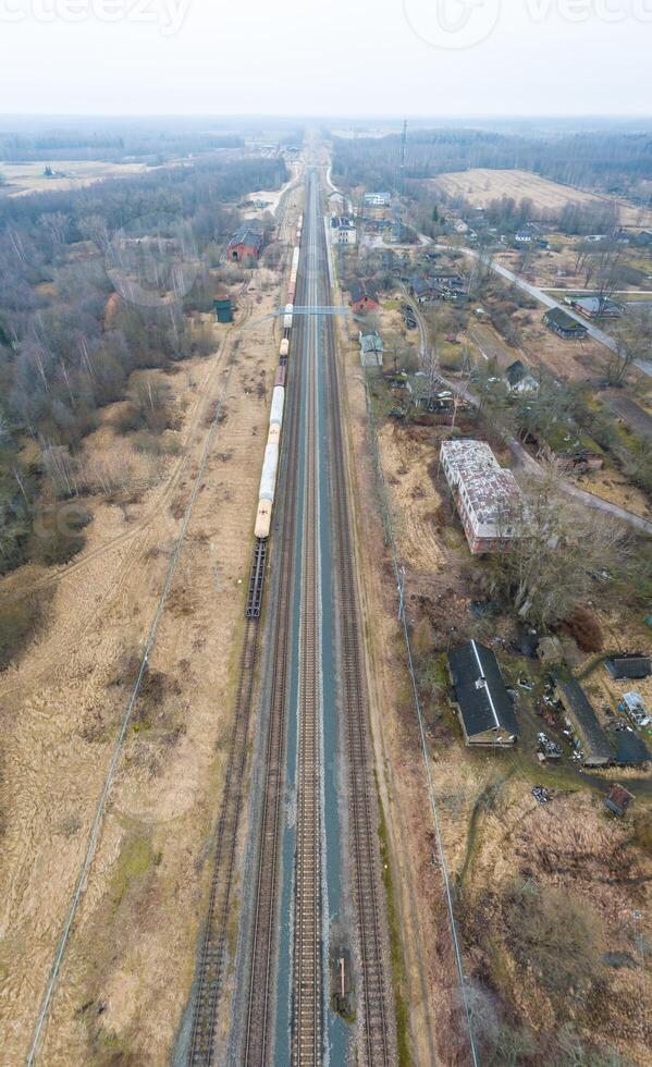 Railway Line Through Rural Landscape with Train and Sparse Buildings photo