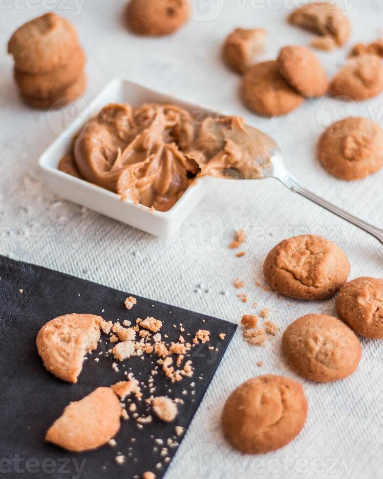 Close Up of Creamy Peanut Butter with Cookies on White Surface photo