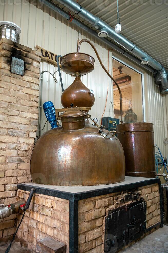 Traditional Copper Distillation Apparatus in Rustic Indoor Setting photo