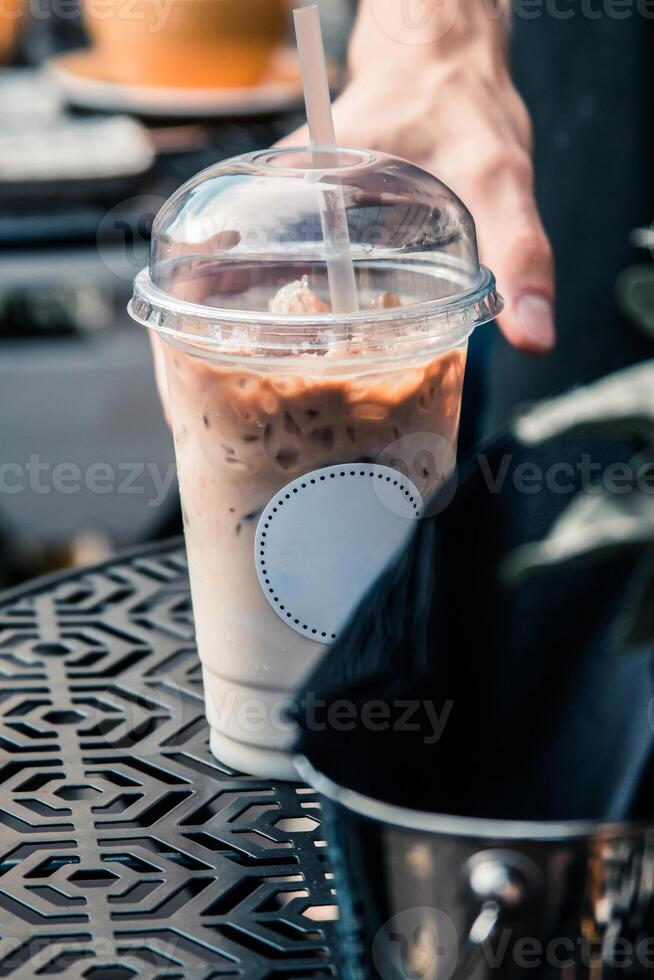 Iced Coffee in Plastic Cup on Patterned Metal Table Outdoors photo