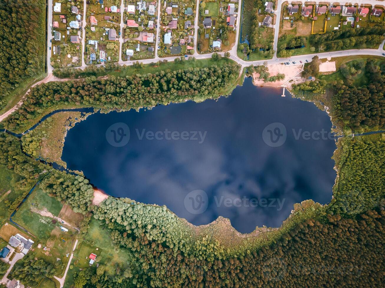 Aerial View of a Forest Lake with Residential Area and Open Fields photo