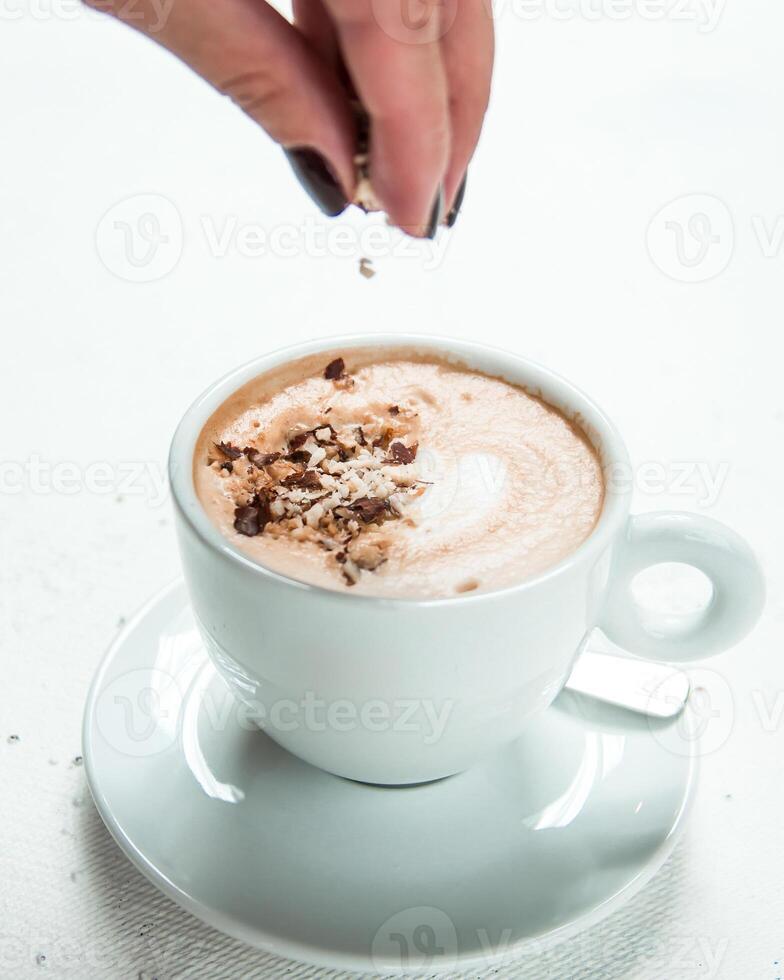 White Ceramic Cup with Illy Logo and Coffee Being Garnished photo