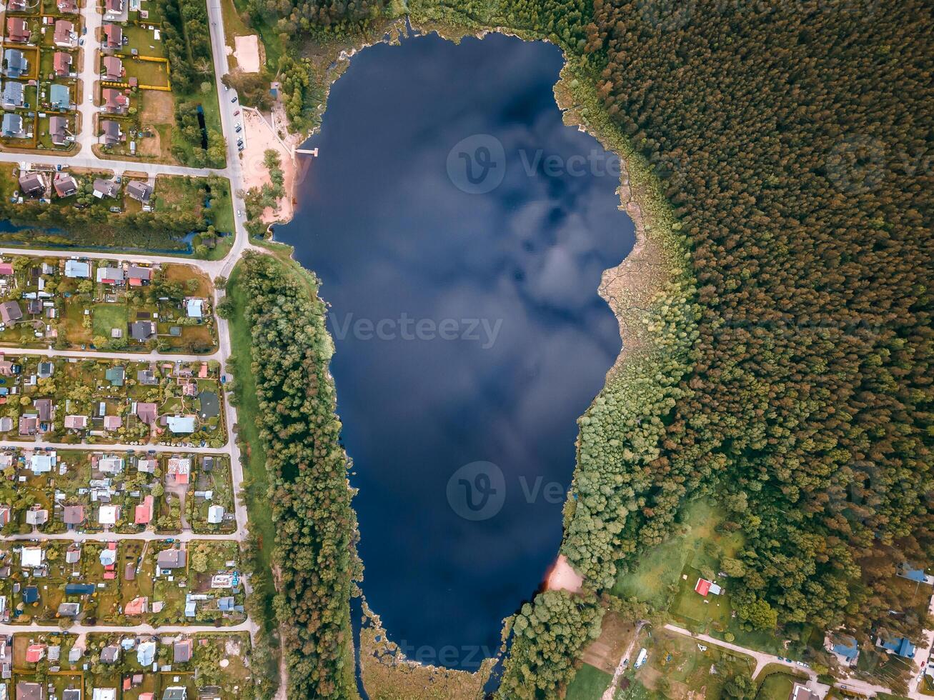 Aerial View of Reflective Lake with Forest and Residential Areas photo