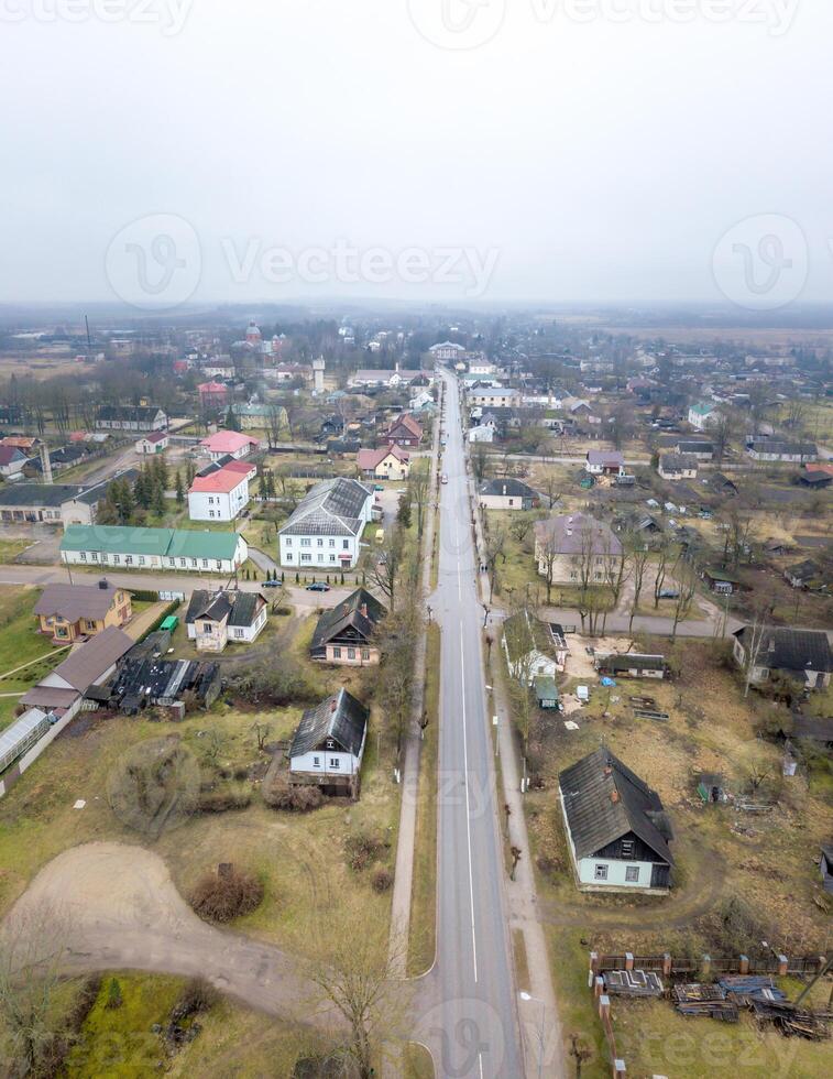 Aerial View of a Small Town with Straight Central Road and Sparse Vegetation photo
