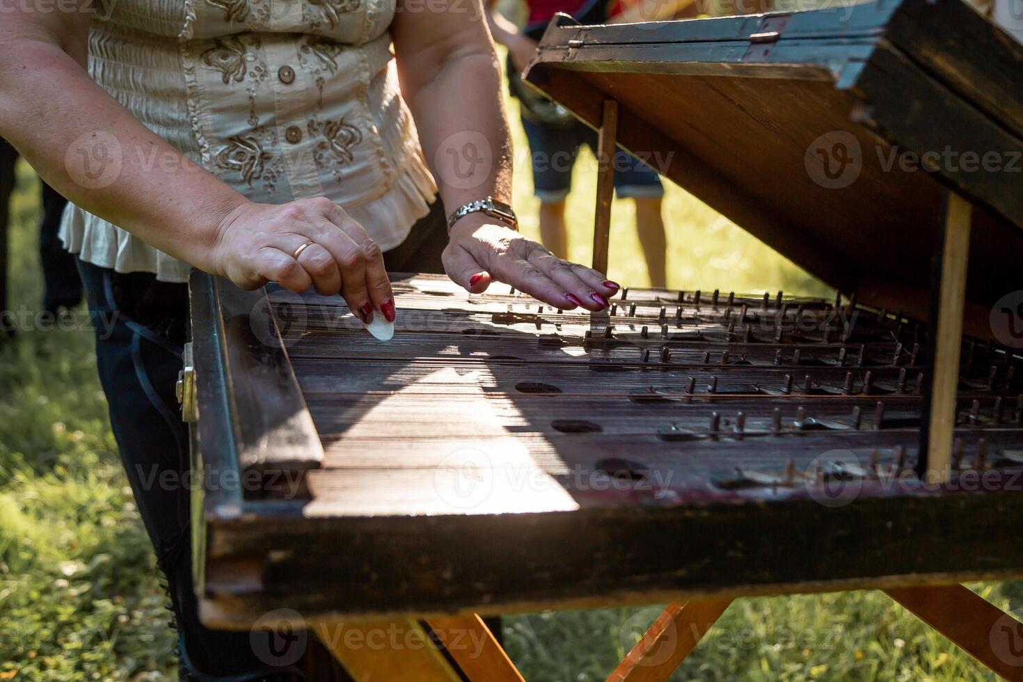 Person Playing Hammered Dulcimer at Outdoor Cultural Event photo