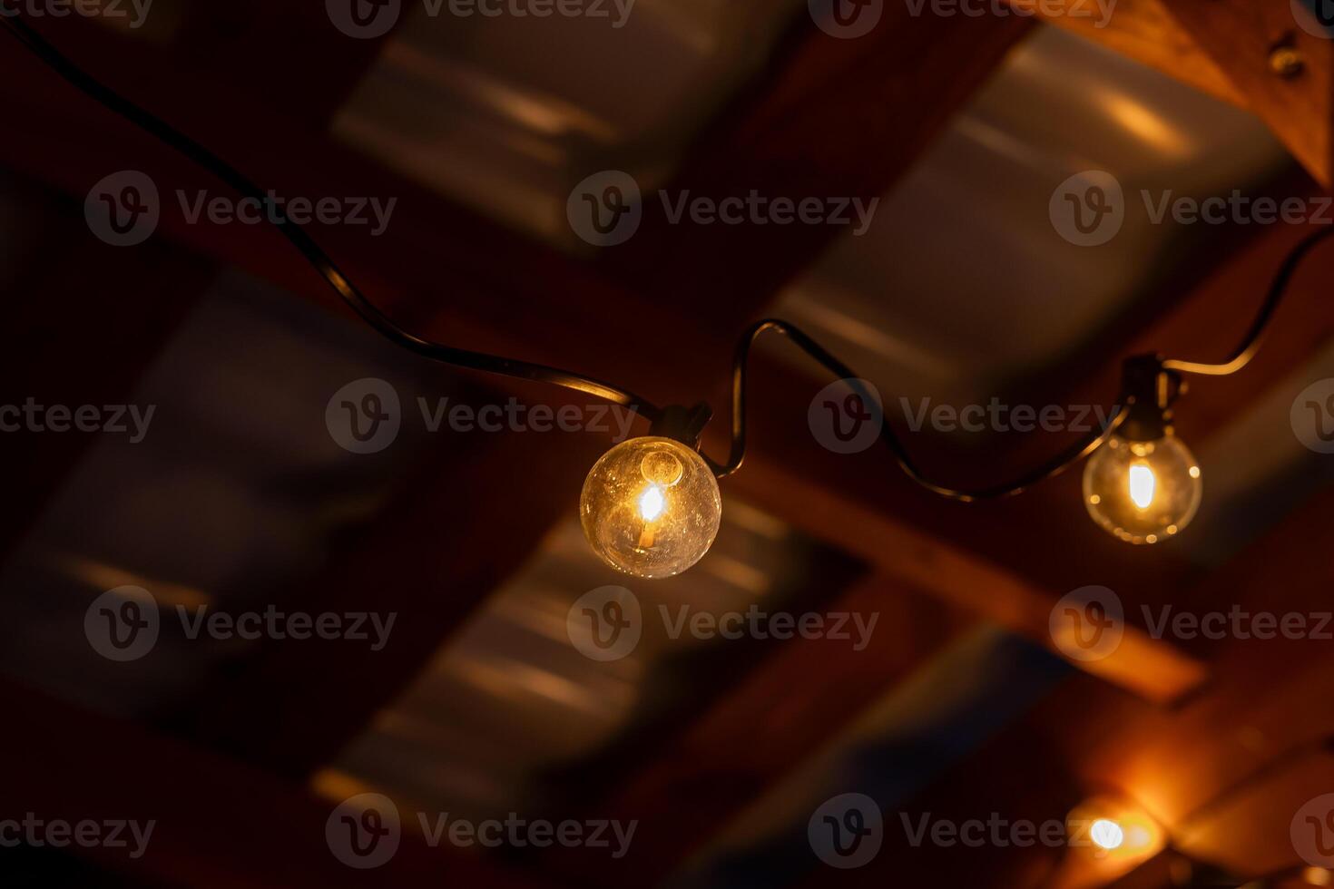 Warm LED String Lights Under Wooden Terrace Roof with Beams photo