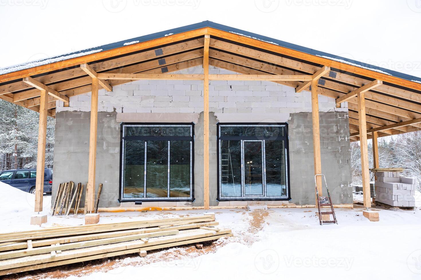 Partially Constructed Building with Snow Covered Ground and Trees photo