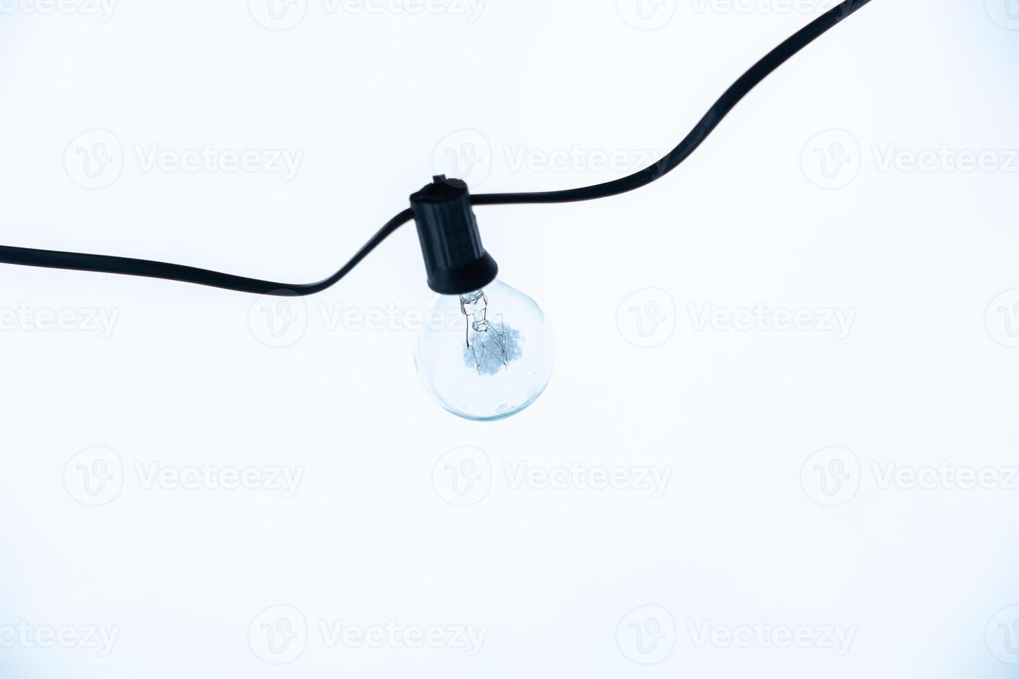Clear LED Bulb Suspended Against an Overcast Sky photo