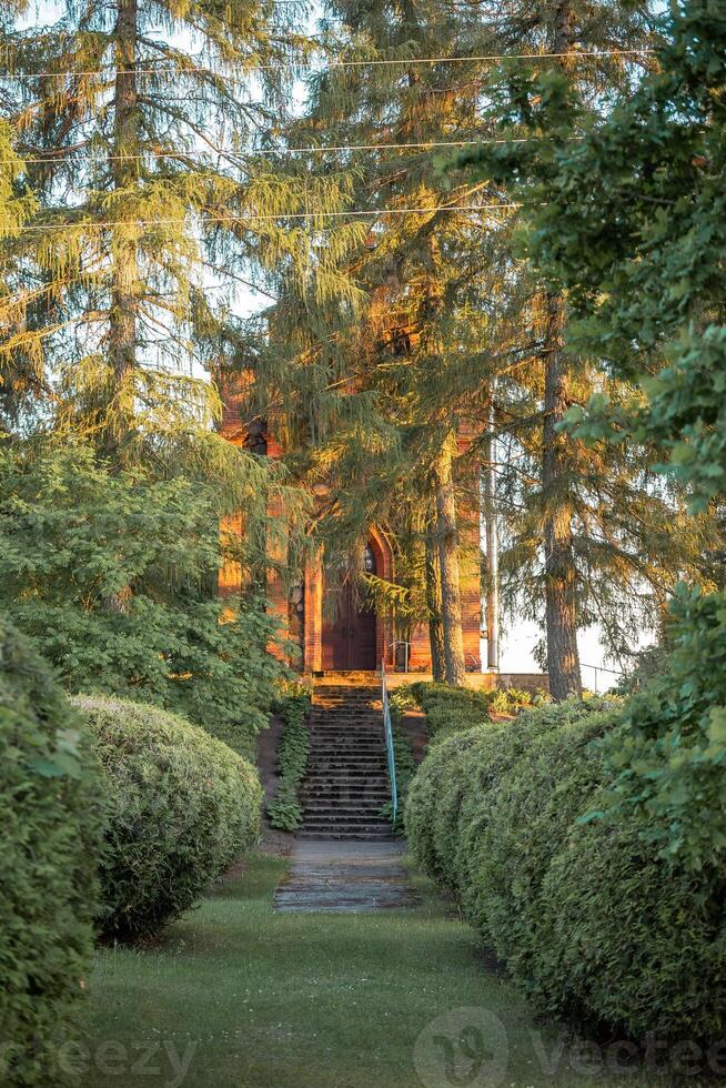 Brick Structure with Arched Doorway in a Tree Lined Garden photo