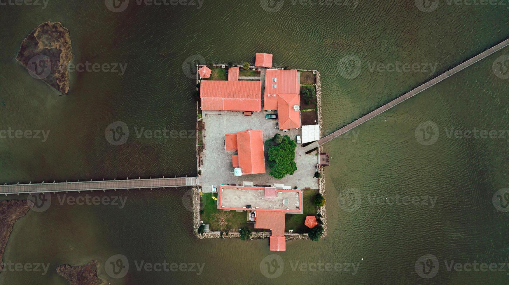Aerial View of Island with Red Roofed Buildings and Stone Wall photo
