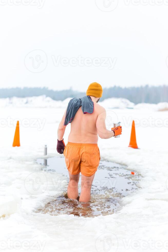 Person Preparing for Ice Swimming in a Snowy Rural Setting photo