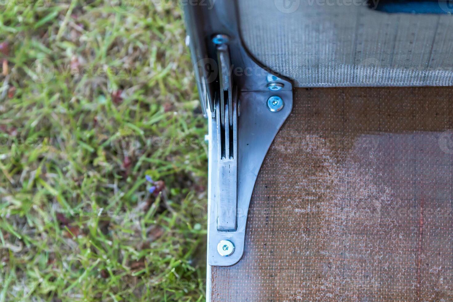 Close Up of Metal Hinge Mechanism on Wooden Surface Outdoors photo
