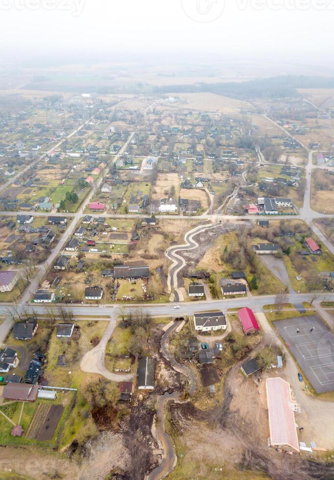 Aerial View of Rural Village with Winding Stream and Scattered Houses photo