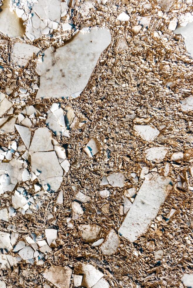 Close Up of Weathered Fragmented White and Beige Surface photo