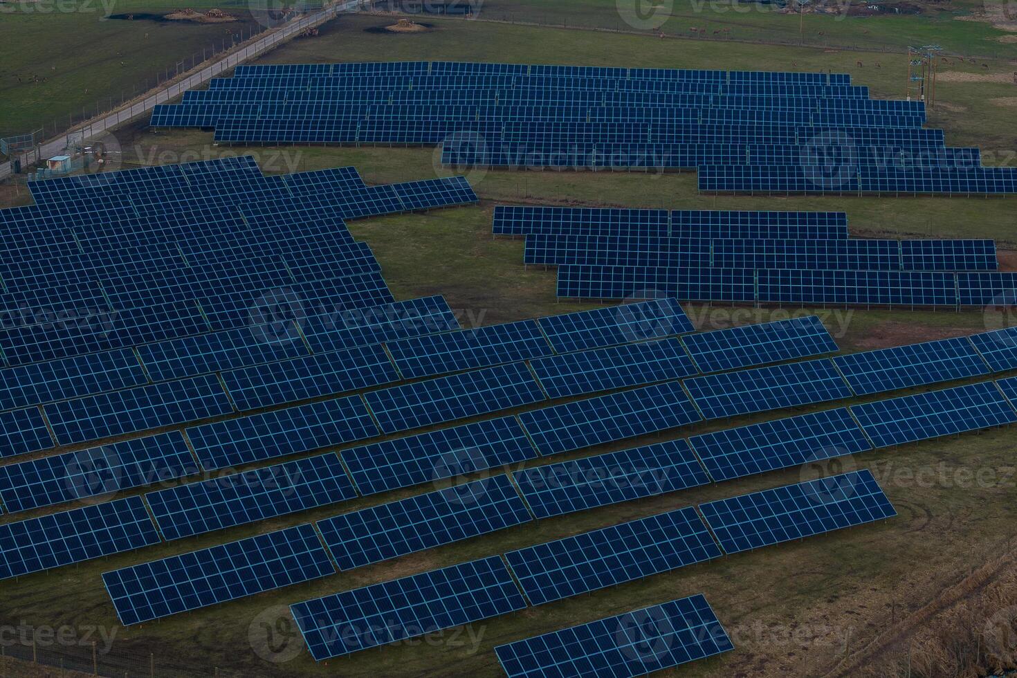 Expansive Solar Farm with Rows of Blue Panels in Open Field photo