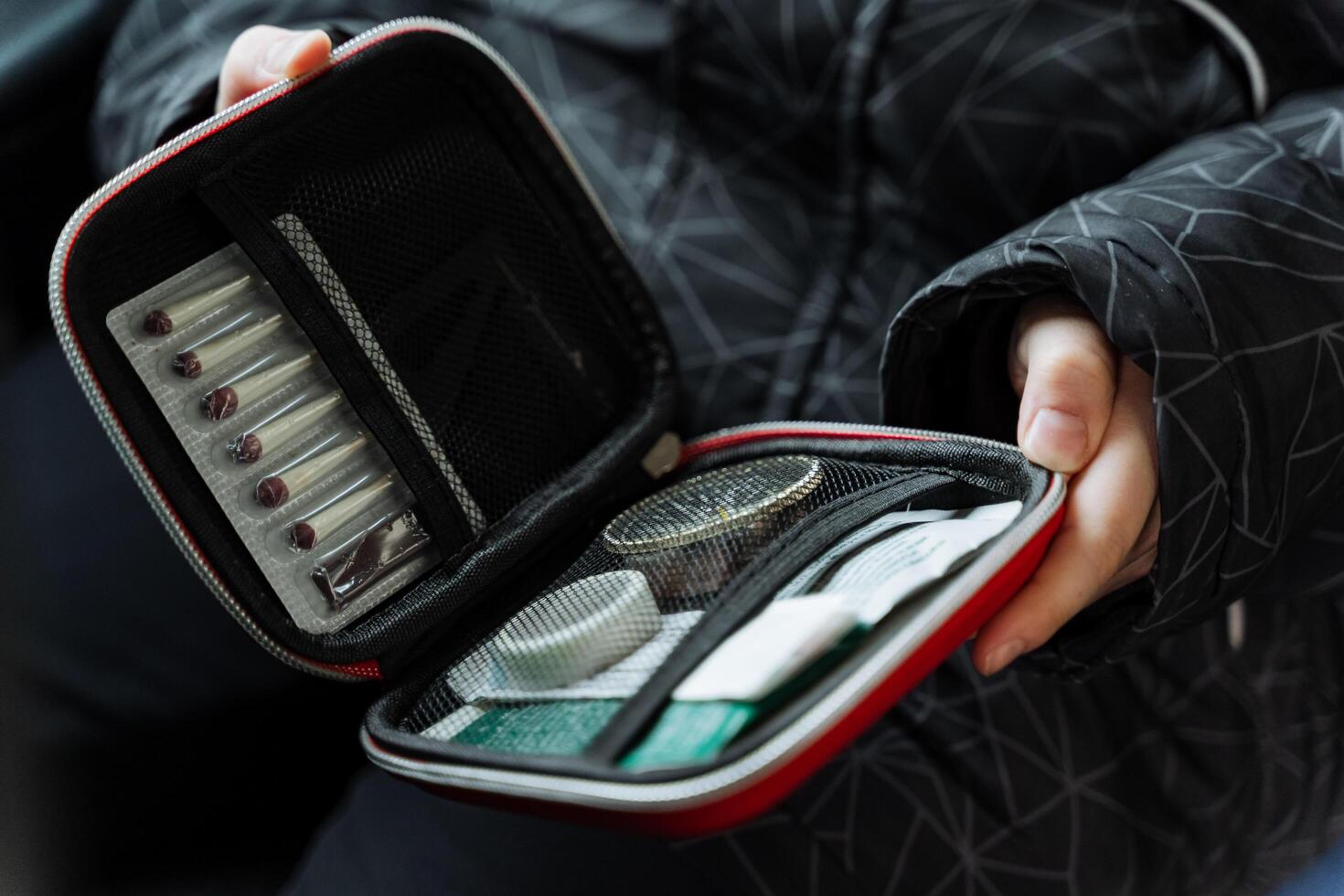 A confident individual is holding a bright and vibrant red case that is packed full of a range of various useful items that are essential for daily life as well as travel activities photo